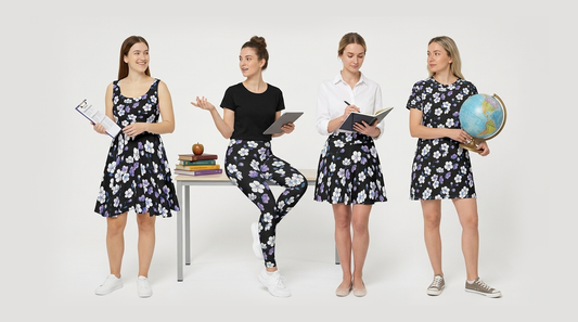 Four women model black floral teacher outfits with purple and white flowers. Teacher accessories include books, a tablet, notebook, and globe.